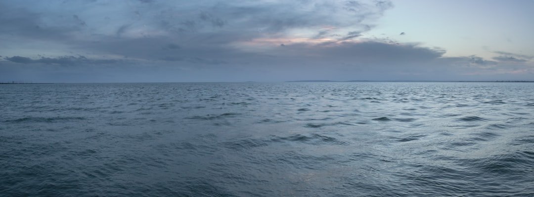 a large body of water under a cloudy sky
