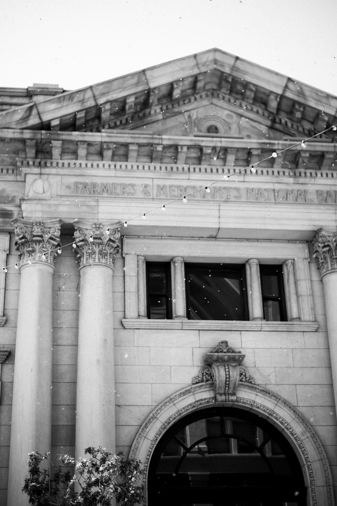 Historic building facade with columns and arched entrance.