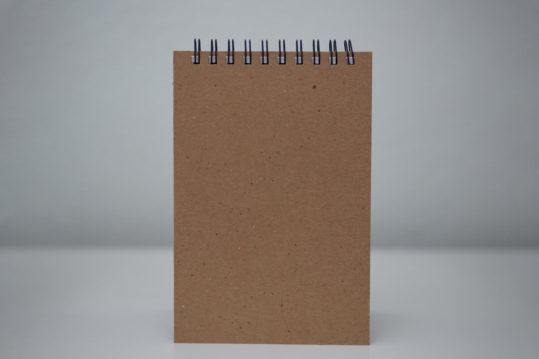 a spiral notebook with a brown cover on a white background