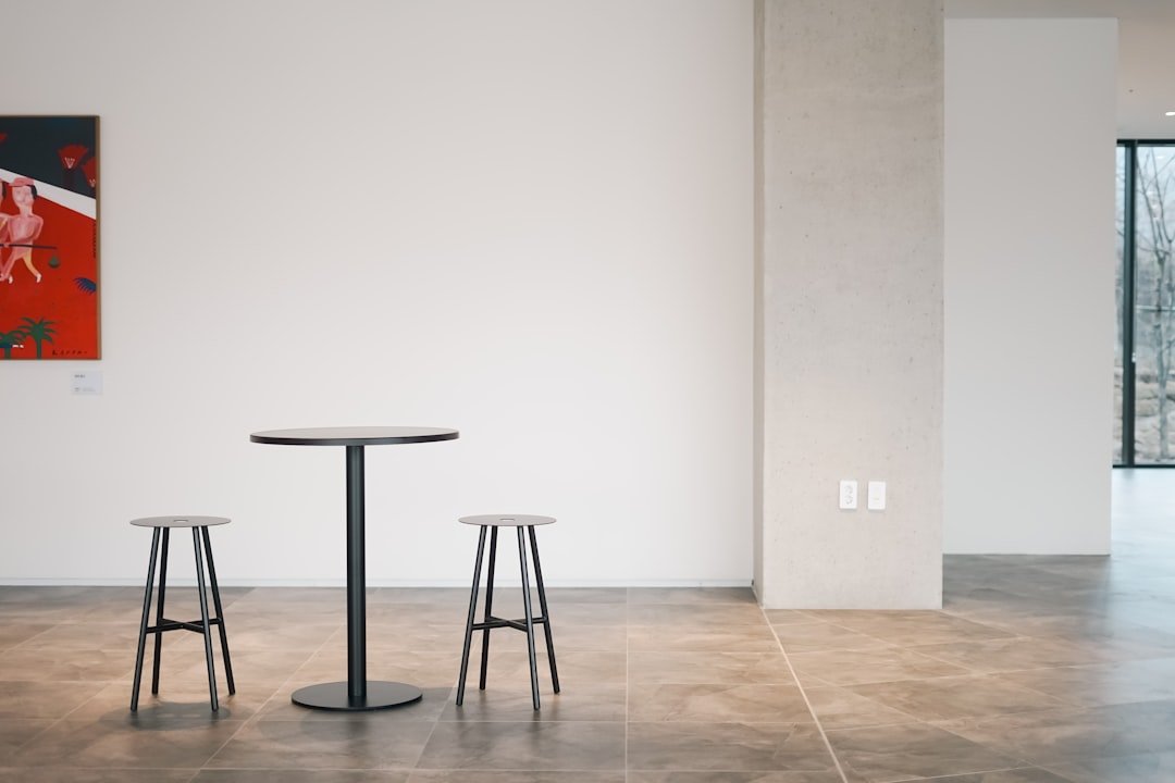 a table and two stools in a room