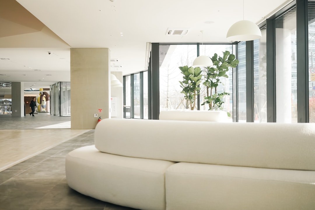 a white couch sitting in a living room next to a tall window