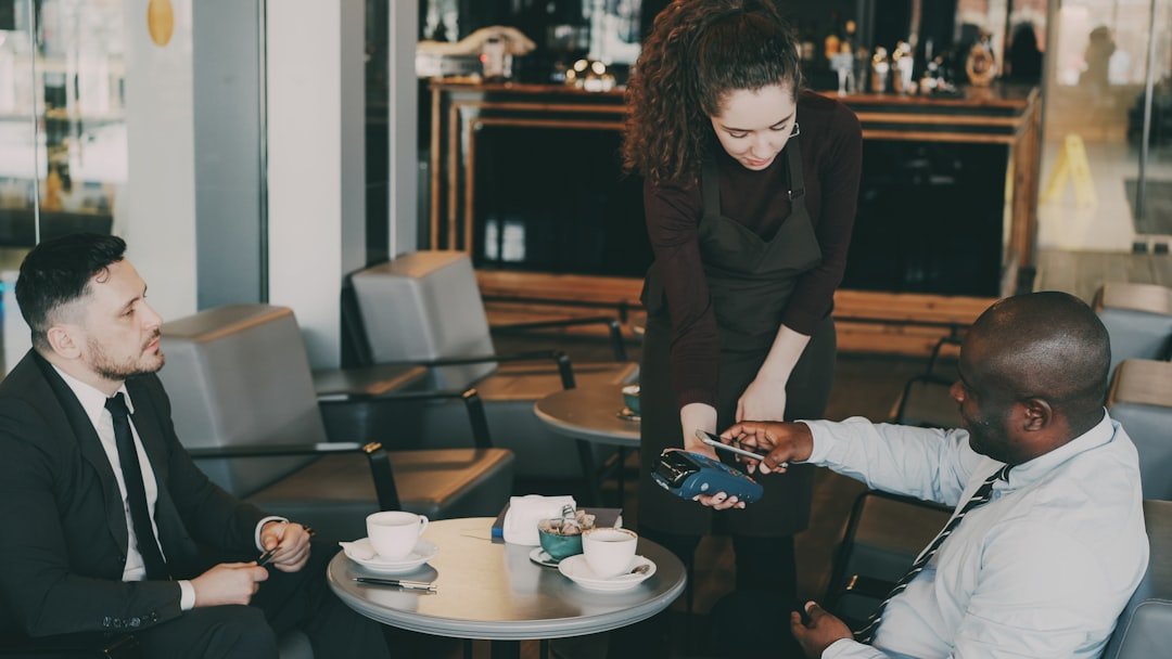 Customer paying with credit card at cafe counter.