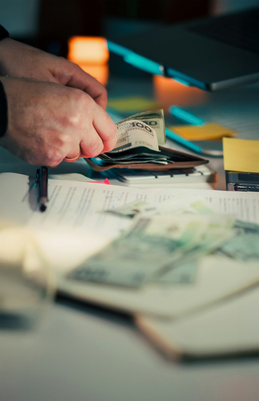 Hands counting money over papers and around papers
