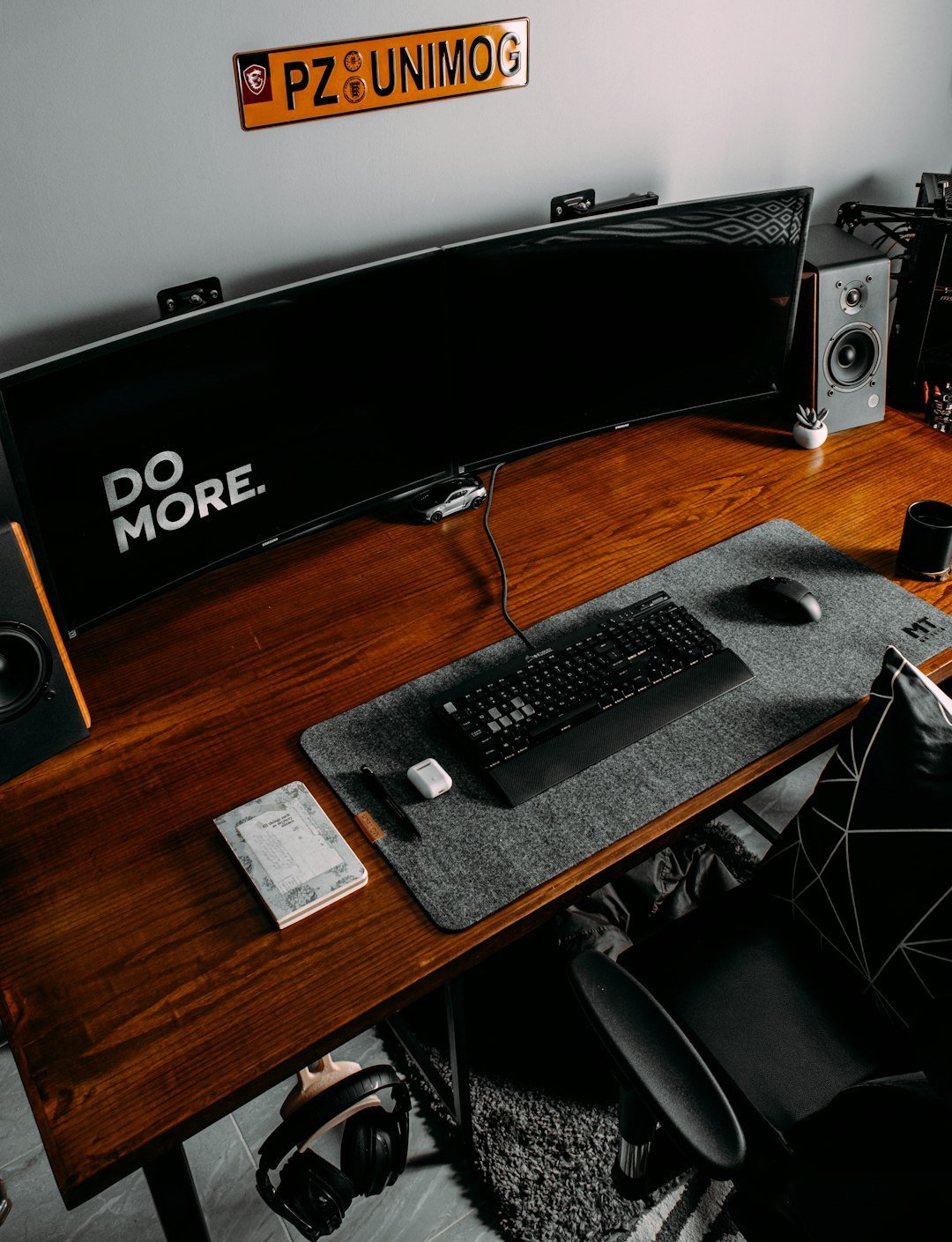 a desk with a keyboard, mouse and speakers