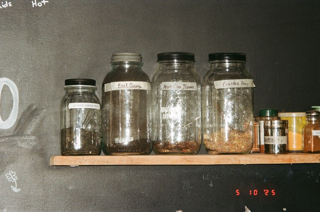 Glass jars with contents are on a shelf.