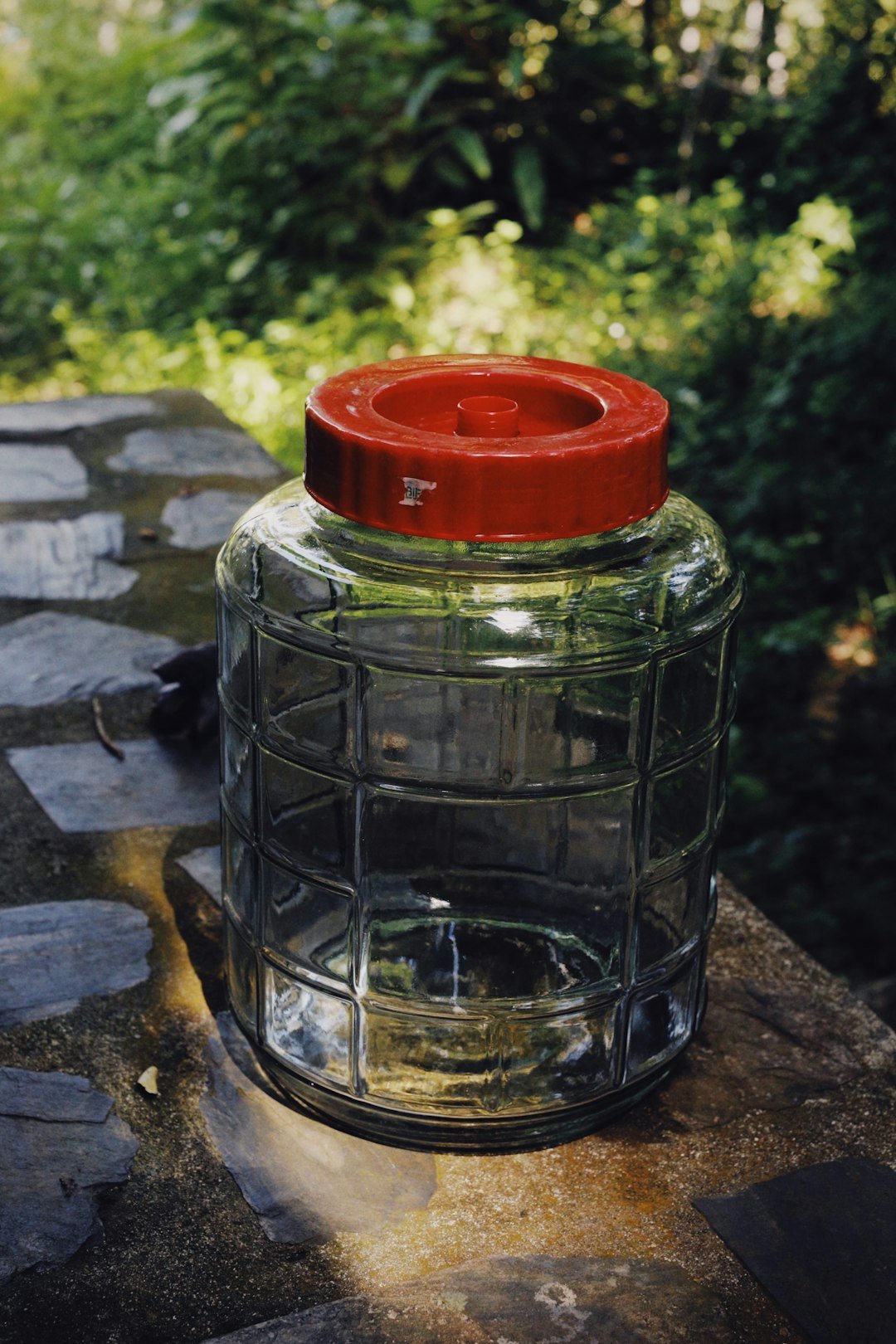 a glass jar with a red lid sitting on a table